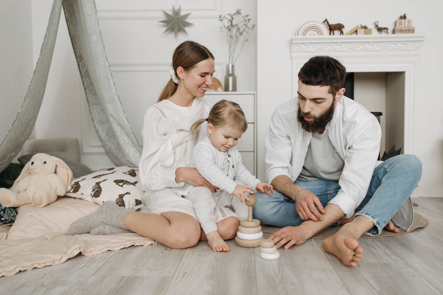 Familie spielt zusammen auf dem Boden im hellen Wohnzimmer